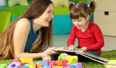 A woman reading with a small girl A woman reading with a small girl